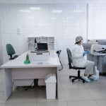Cientista trabalha atentamente em um laboratório equipado.
