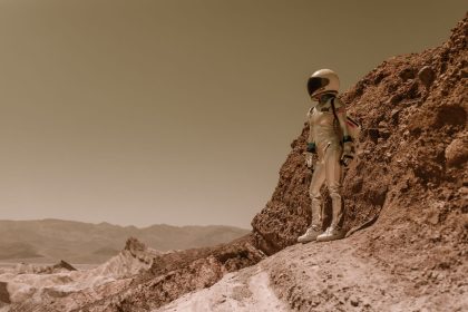 Astronauta em traje espacial sobre terreno rochoso semelhante à superfície de Marte.