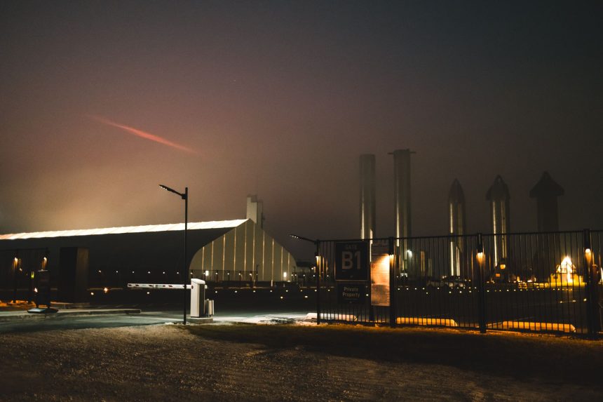 Instalação da SpaceX em Brownsville, no Texas, vista à noite entre névoa e luzes.