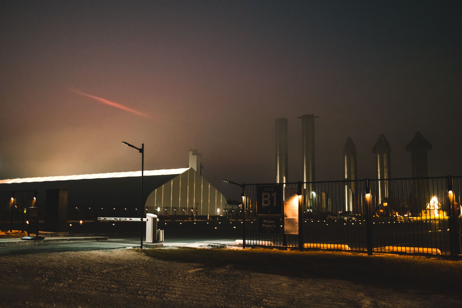 Instalação da SpaceX em Brownsville, no Texas, vista à noite entre névoa e luzes.
